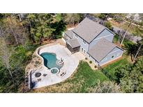 Stunning aerial view of a two-story home and backyard featuring a modern pool, spa, and fire pit at 125 Arrow Point Ln, Davidson, NC 28036