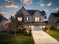 Charming two-story home featuring stone accents, a well-manicured lawn, and an attached two-car garage at 2033 Folkstone Ln, Indian Land, SC 29720