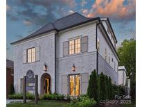 Elegant two-story home featuring a blend of white brick and siding, accentuated by dark roof and shutter details at 238 Laurel S Ave # B, Charlotte, NC 28207