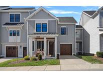 Charming two-story home features a covered front porch, attached garage, and tasteful gray siding at 2721 Kilgo Way, Charlotte, NC 28205