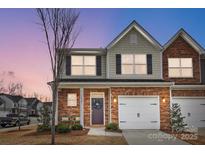 Charming townhome exterior featuring a well-maintained lawn and a welcoming front entrance with a wreath at 3925 Rothwood Ln, Harrisburg, NC 28075