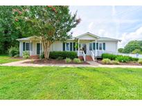 Charming single-story home featuring a well-maintained lawn, inviting front porch, and accessible ramp at 4009 Polkville Rd, Shelby, NC 28150