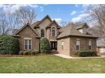Charming brick home featuring manicured lawn, mature landscaping and covered entry at 7006 Waggoners Glen Ln, Charlotte, NC 28226