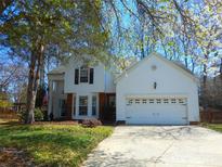 Charming two-story home with a manicured lawn and attached two-car garage and mature trees at 9331 Hanworth Trace Dr, Charlotte, NC 28277