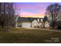 Charming single-Gathering home with a two-car garage, well-maintained lawn and cozy curb appeal at sunset at 111 Lynnette Dr, Mt Ulla, NC 28125