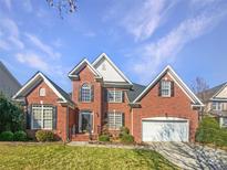 Charming two-story brick home featuring a well-manicured lawn and attached two-car garage at 1421 Wilburn Park Nw Ln, Charlotte, NC 28269