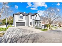 Beautiful two-story home featuring well-maintained landscaping, a gray garage door, and a basketball hoop at 14625 Harvington Dr, Huntersville, NC 28078