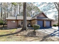 Charming single-story home with a brick facade and a two-car garage nestled amongst mature trees at 2652 Gabriel Ct, Fort Mill, SC 29715