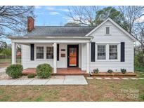 Charming home featuring a cozy front porch, brick accents, and freshly painted white siding at 2900 Morson St, Charlotte, NC 28208