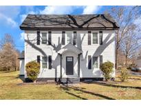 Charming two-story home featuring a gray roof, a black door and shutters, and a well-maintained front lawn at 606 N Elm St, Marshville, NC 28103