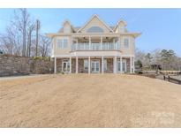 Expansive waterfront property featuring a grand facade and stone retaining wall at 627 Birdie Ln # 21/22, Norwood, NC 28128