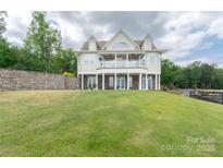 Beautiful lakefront home featuring a large lawn and multiple outdoor spaces at 627 Birdie Ln # 21/22, Norwood, NC 28128