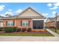 Home exterior with landscaped yard, an enclosed porch, and American flag displayed at 8439 Sonata Ct, Denver, NC 28037