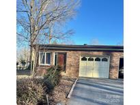 Cozy single-story brick home featuring an attached garage and well-maintained landscaping at 1049 7Th Ne St, Hickory, NC 28601