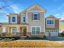 Charming two-story home features stone accents, a covered porch, and an attached two-car garage at 12326 Cranberry Glades Dr, Cornelius, NC 28031