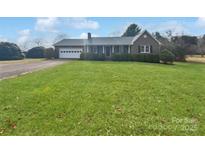 Charming brick home with attached garage, manicured hedges, and a lush green front yard at 189 Beech Brook Ln, Statesville, NC 28625