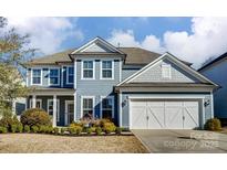 Charming two-story home with blue siding, white trim, and a well-manicured front yard at 2056 Angel Oak Dr, Fort Mill, SC 29715