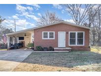 Charming brick ranch home with covered carport featuring outdoor seating and well-maintained yard at 2320 Monterey Park Dr, Gastonia, NC 28054