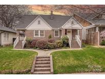 Charming brick home with a landscaped front yard and inviting front porch with white railings at 304 W Park Ave, Charlotte, NC 28203