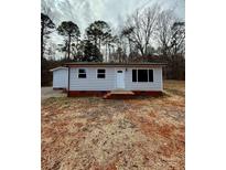 Charming single-story home featuring light gray siding, a red brick foundation and a well-manicured yard at 3437 Wilkesboro Hwy, Statesville, NC 28625
