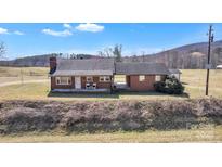 Charming brick home featuring a welcoming front porch and a beautiful countryside setting at 6231 Nc 16 N Hwy, Taylorsville, NC 28681