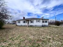 Quaint one-story home with white siding, a chimney, and a spacious front yard at 930 Weaver Rd, China Grove, NC 28023