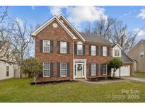 Charming two-story brick home with a well-manicured lawn and beautiful landscaping at 10001 Wild Dogwood Ct, Charlotte, NC 28273