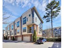 Modern townhome featuring a 1-car garage, brick facade, and blue and cream exterior paint at 1037 Pierre Dr, Charlotte, NC 28205