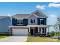 Charming two-story home featuring blue siding, stone accents, covered porch, and a two-car garage at 136 Glenn Dr, Mooresville, NC 28115