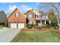 Charming brick home with a two-car garage, manicured lawn, and inviting front porch at 2000 Willowcrest Dr, Waxhaw, NC 28173