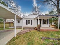 Charming one-story home with white siding, covered porches, and a convenient carport for parking at 211 9Th St, Belmont, NC 28012