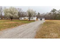 Charming home with white siding, black shutters, wooden porch, and a long gravel driveway at 288 John L Hudson Sr Rd, Lancaster, SC 29720