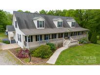 Inviting two-story home featuring a spacious front porch and manicured lawn at 3199 Harmony Rd, Catawba, SC 29704