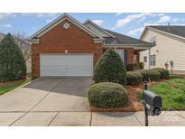 Charming one-story brick home with manicured landscaping and an attached two-car garage at 418 Garnet Ct, Fort Mill, SC 29708