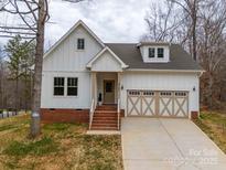 Charming two-story home featuring a white exterior, brick foundation, and a two-car front-facing garage at 5101 Thornhill Dr, Gastonia, NC 28052