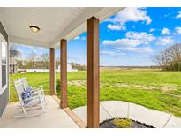 Inviting porch with rocking chairs and stunning views of the lush green landscape and serene sky at 5405 Austin Rd, Monroe, NC 28112