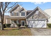 Charming two-story home featuring a welcoming front porch and a two-car garage with well-maintained landscaping at 7003 Dacian Ln, Indian Trail, NC 28079