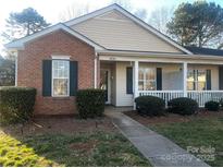 Charming single-story home with brick and vinyl siding and a covered front porch, complemented by manicured landscaping at 9734 Kennerly Cove Ct, Charlotte, NC 28269