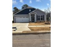 Charming single-Gathering home with two-car garage, gray siding, and professionally landscaped front yard at 1429 Nia Rd, Charlotte, NC 28215