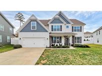 Charming two-story home with white siding, blue accents, a well-maintained lawn, and an attached two-car garage at 2408 Napa Ter, Clover, SC 29710