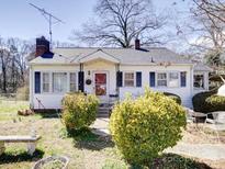 Charming single-story home featuring a cozy front porch, a well-maintained lawn, and mature landscaping at 1043 Ridge Ave, Gastonia, NC 28052