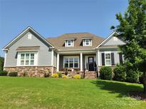 Charming home exterior features a well-manicured lawn and stone accents, enhancing curb appeal at 107 Hillside Cove Ct, Mooresville, NC 28117