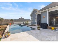 Backyard pool area featuring a pool, spa, and travertine tile at 107 Hillside Cove Ct, Mooresville, NC 28117