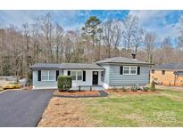 Charming single story home featuring gray siding, black shutters, and a well-maintained front yard at 1404 Nottingham Rd, Kannapolis, NC 28081