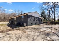 A side view of the home's backyard showing a concrete patio and the home's exterior at 1536 Plyler Lake Rd, Gastonia, NC 28054