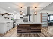 Bright kitchen features stylish island, modern appliances, and floating shelves at 1536 Plyler Lake Rd, Gastonia, NC 28054
