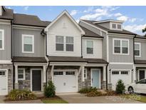 Charming townhome featuring a stone veneer, white garage door, and a light blue front door at 2004 Crooked Oak Ln, York, SC 29745