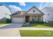 Charming single-story home featuring a two-car garage, landscaped front yard, and welcoming red front door at 333 Dudley Dr, Fort Mill, SC 29715
