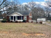 Cozy brick home featuring a screened-in porch and well-maintained front yard at 4137 Poplar Tent Rd, Concord, NC 28027