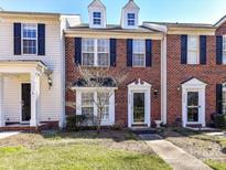 Charming brick townhome with black shutters, a well-maintained lawn, and a welcoming front door at 9410 Cadman Ct, Cornelius, NC 28031